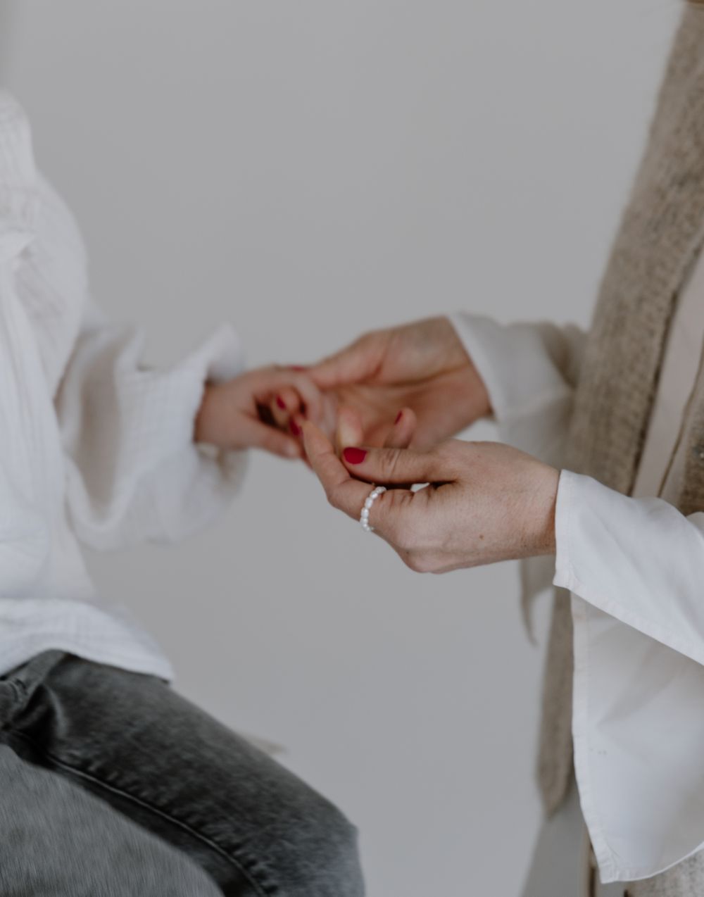 Erwachsene Hand hält die Hand eines Kindes